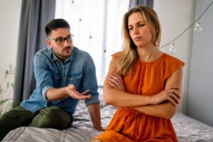 Sad pensive couple thinking of relationships problems sitting on sofa, conflicts in marriage, upset couple after fight dispute