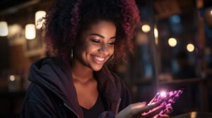 A woman in the dark smiling down at her phone